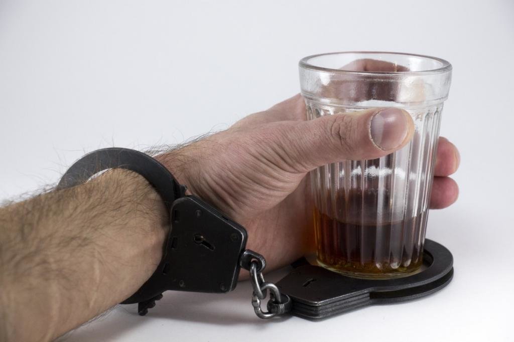 мужчина прикован наручниками к стакану